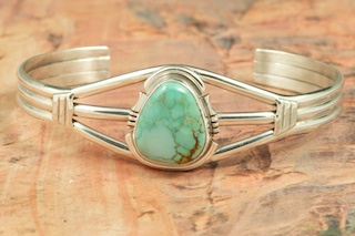 Genuine Royston Turquoise set in Sterling Silver Bracelet.  Created by Navajo Artist Arkie Nelson. Signed by the artist.  Royston Turquoise Mine was originally known as the Royal Blue Mine. It produces Turquoise that has a mixture of blues and greens in the same formation. The Royston Turquoise Mine is located in Nye County, Nevada. 
